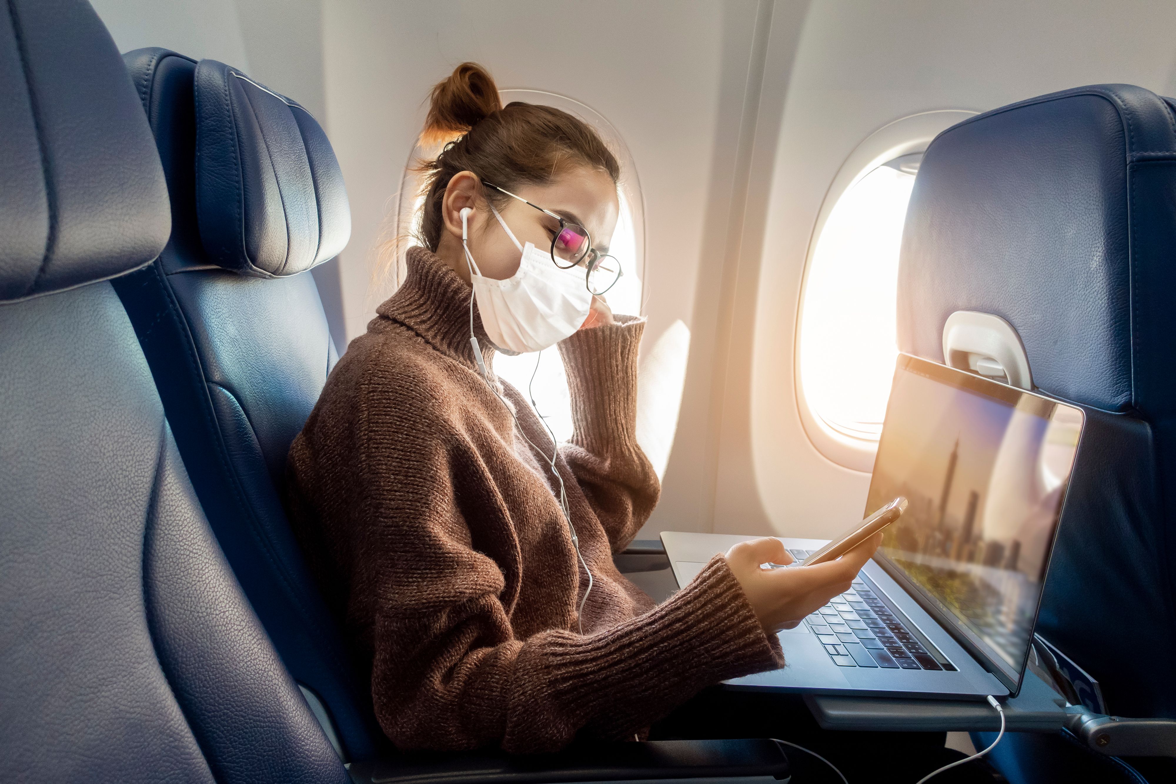 A vacina contra o coronavírus está prestes a mudar as viagens permanentemente: aqui está o que saber 2 uma mulher usando uma máscara facial em um avião