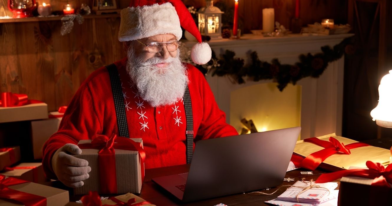 Estes destinos ao redor do mundo celebram o Natal o ano todo 1 Papai Noel em um laptop bebendo café