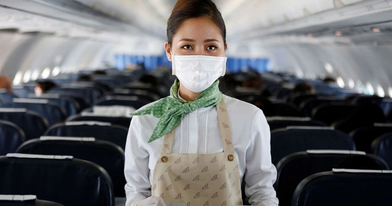 10 comissários de bordo revelam como é trabalhar durante a pandemia de COVID-19 1 um comissário de bordo usa uma máscara médica em um voo