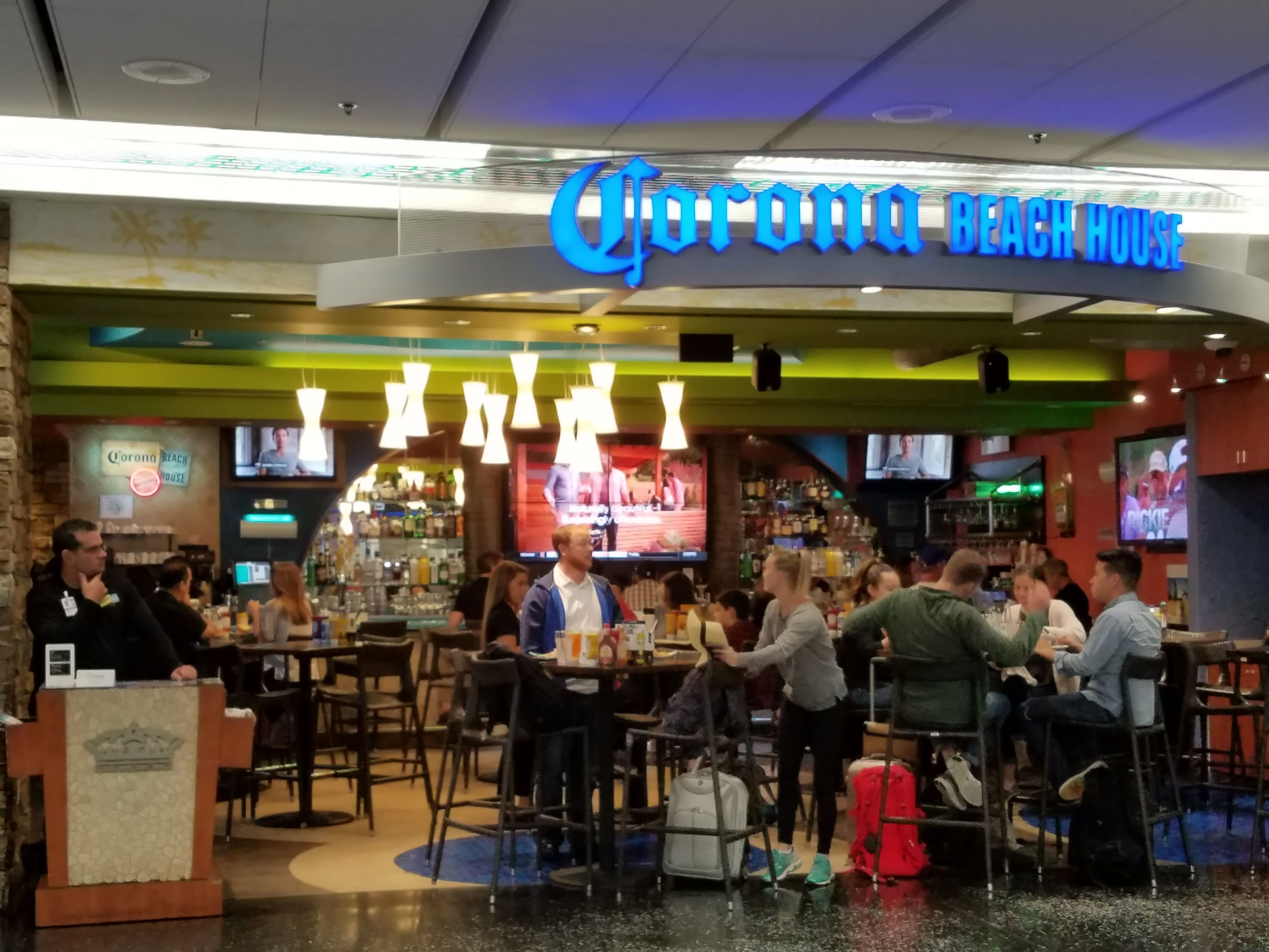 Pessoas sentadas em um bar do aeroporto