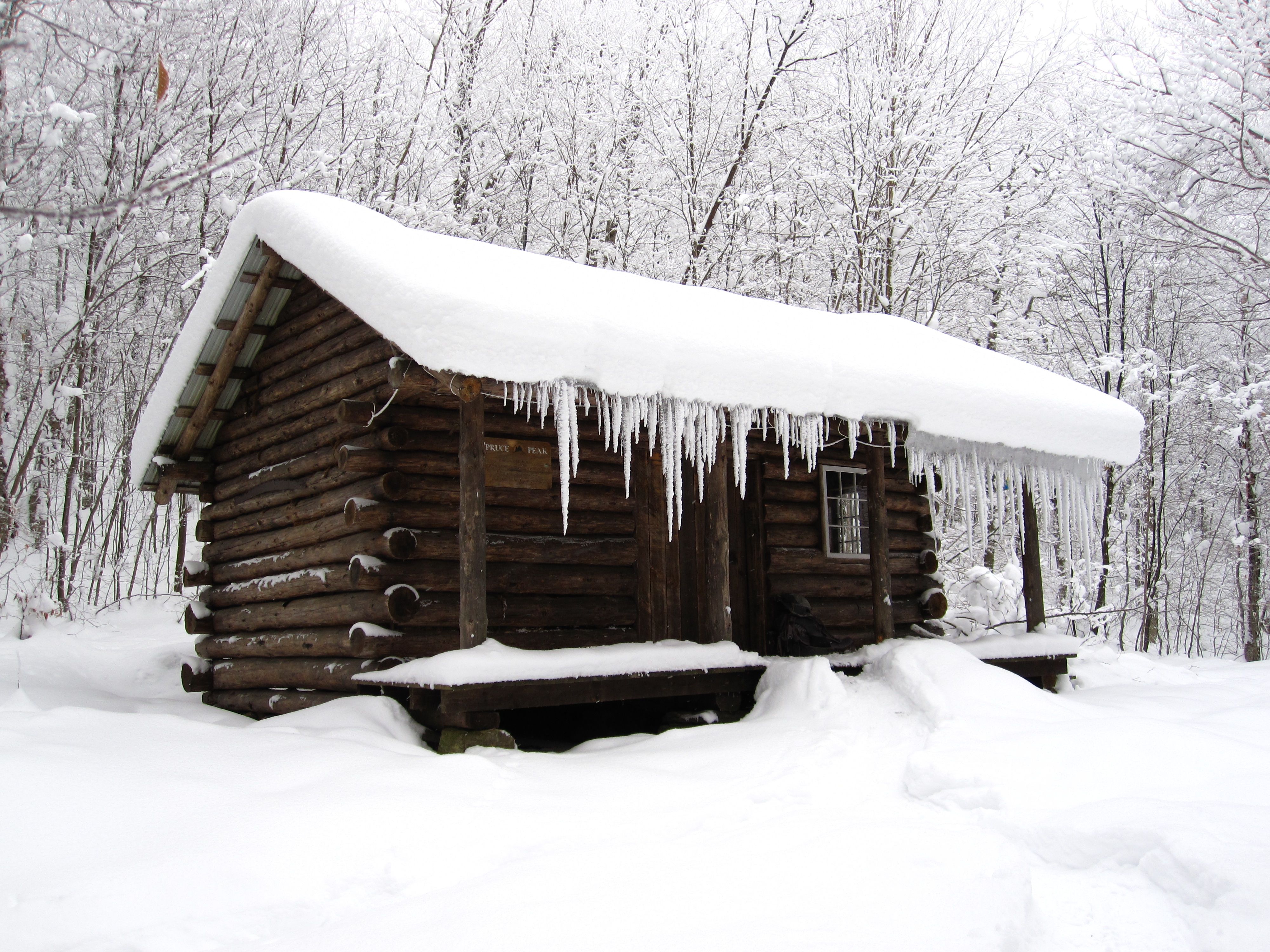 uma cabana de madeira em vermont durante o inverno